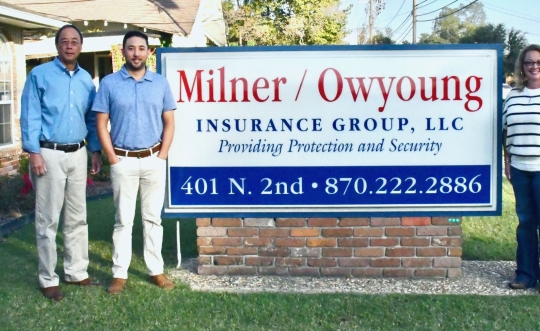 Photo of Milner Owyoung Insurance staff with sign saying the business name.