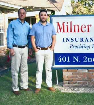 Photo of Milner Owyoung Insurance staff with sign saying the business name.